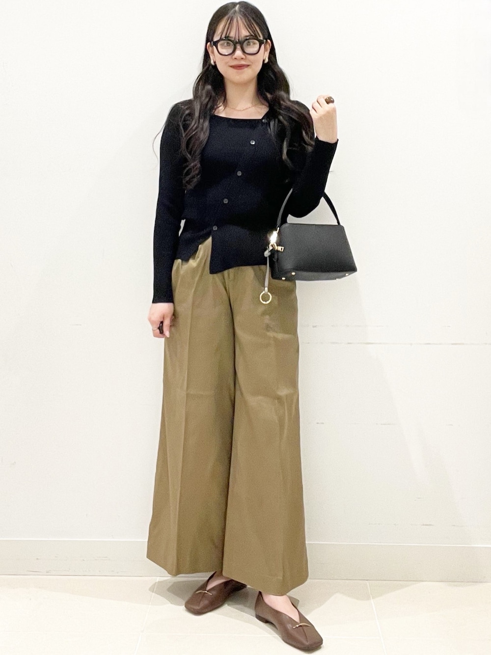 ブラウン系のその他シューズ、ベージュ系のその他パンツ、ブラック系のショルダーバッグを着用したレディースの冬コーディネートの1枚目の写真