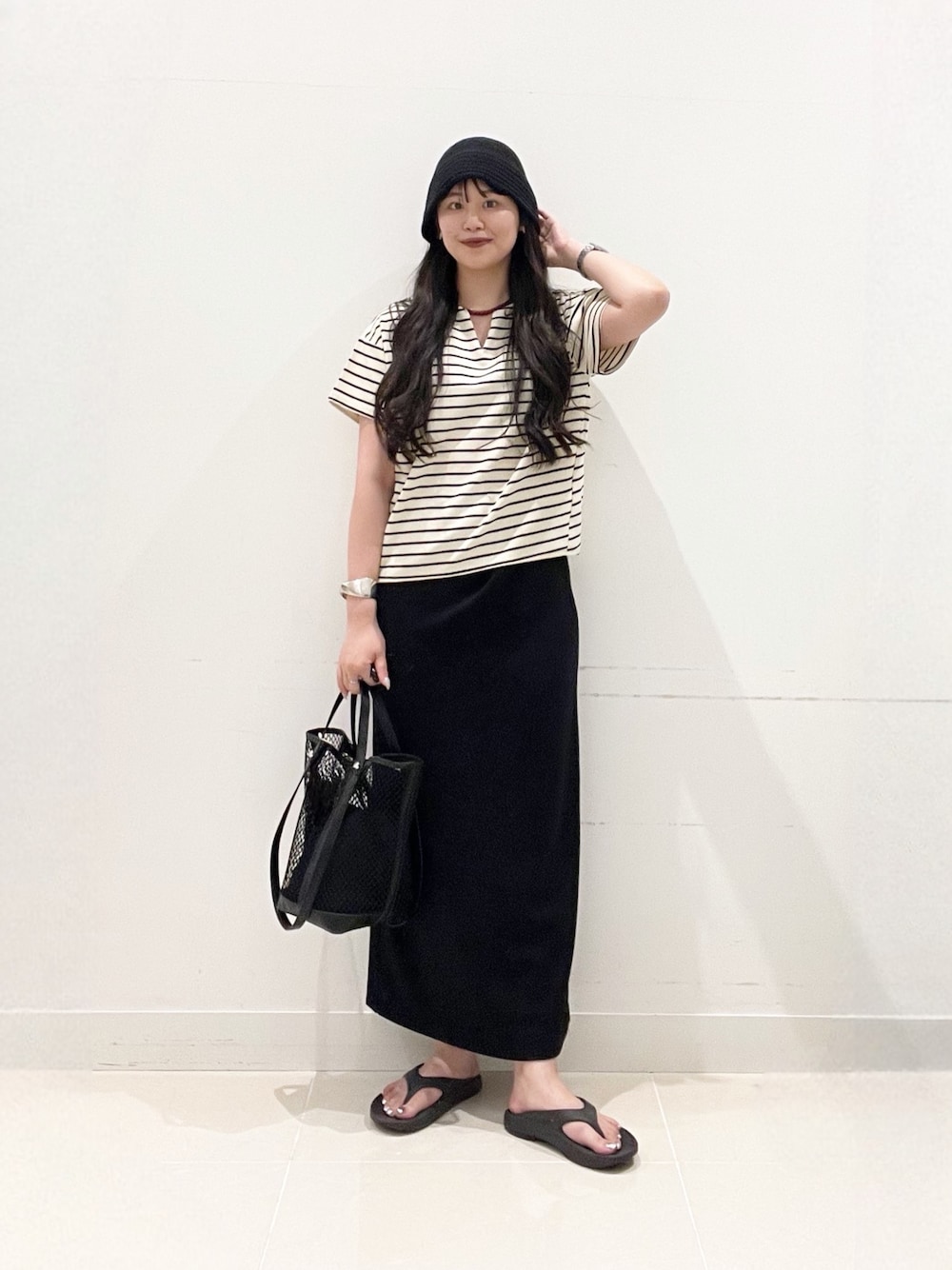 ホワイト系のTシャツ/カットソー、ブラック系のスカート、ブラック系のトートバッグを着用したレディースの夏コーディネートの1枚目の写真