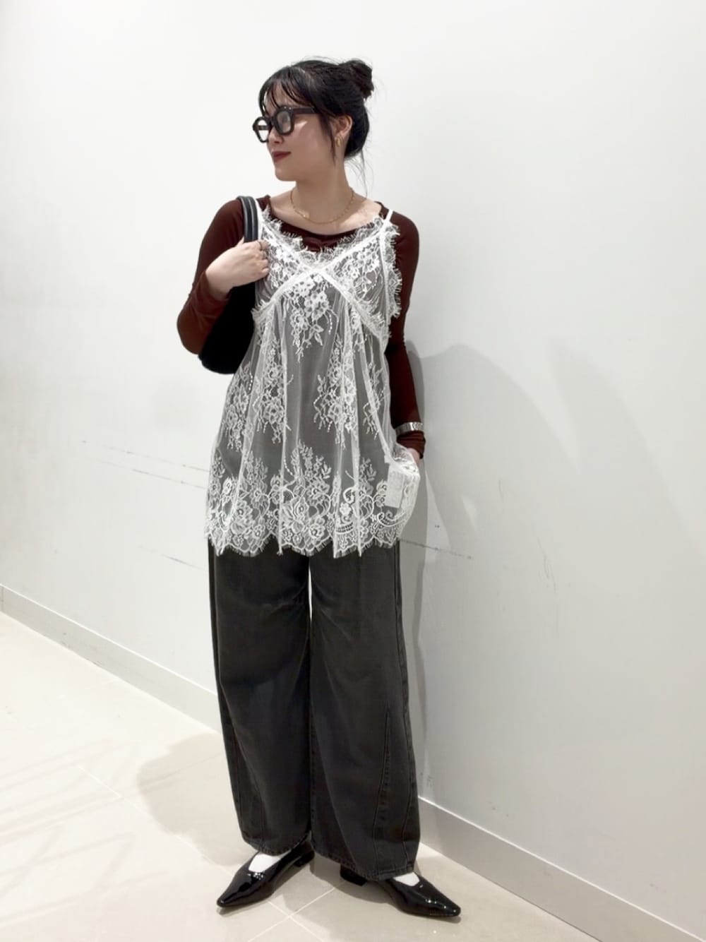 ブラウン系のTシャツ/カットソー、ホワイト系のキャミソール、グレー系のデニムパンツを着用したレディースの秋コーディネートの1枚目の写真