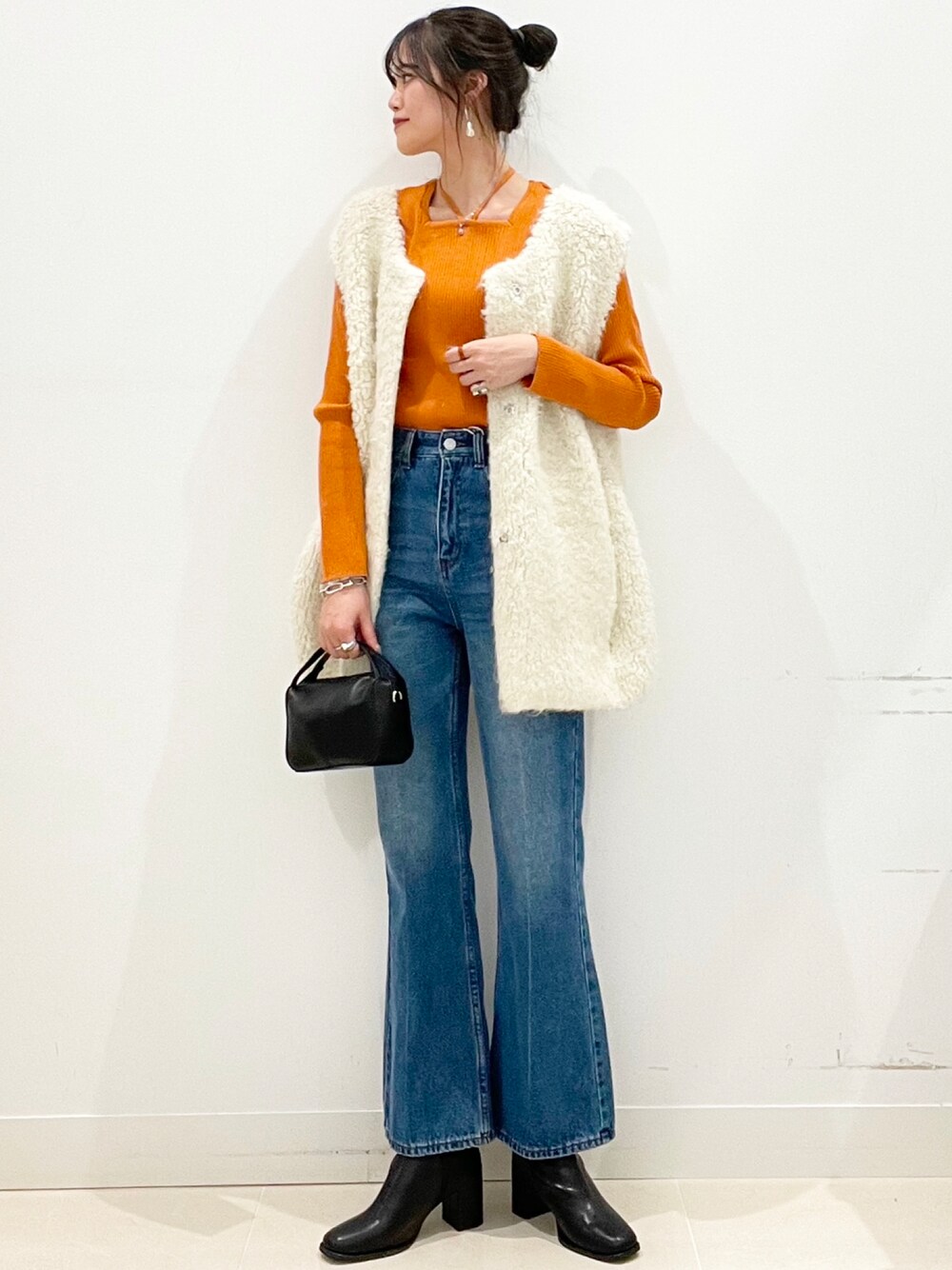 ブルー系のデニムパンツ、ブラック系のブーツを着用したレディースの冬コーディネートの1枚目の写真