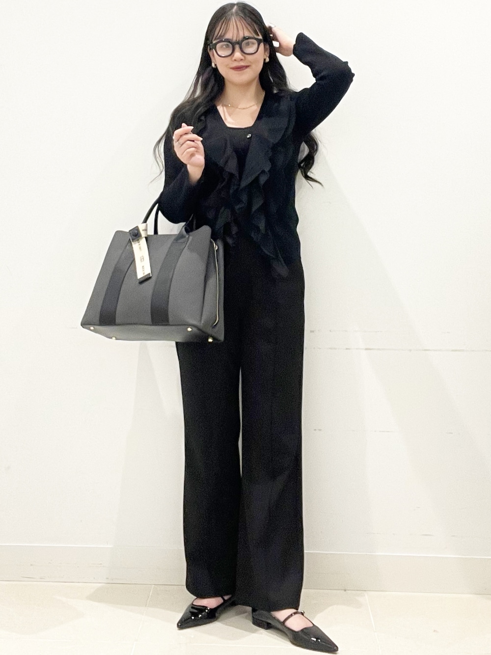 ブラック系のパンプス、ブラック系のトートバッグ、ブラック系のキャミソールを着用したレディースの冬コーディネートの1枚目の写真