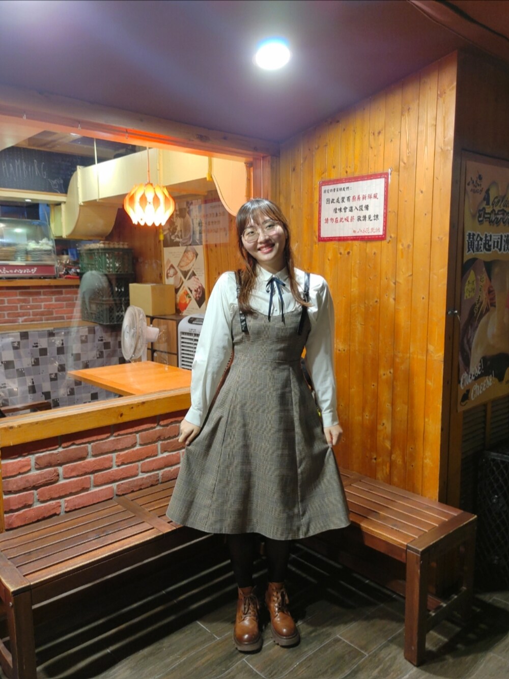 レッド系のジャンパースカート、ホワイト系のシャツ/ブラウスを着用したレディースの冬コーディネートの1枚目の写真