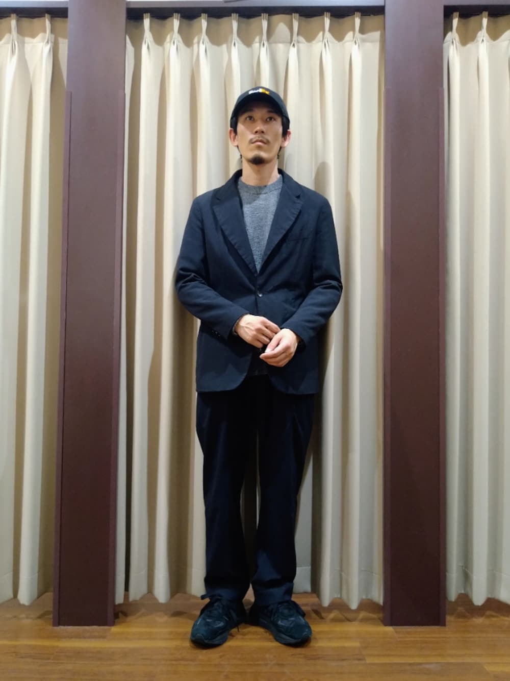 グレー系のニット/セーター、ブルー系のテーラードジャケット、ブルー系のパンツを着用したメンズの冬コーディネートの1枚目の写真