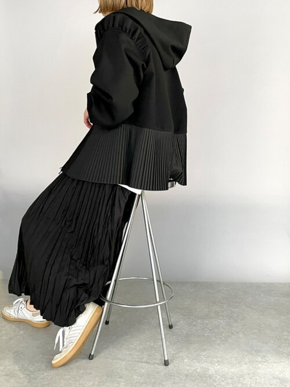 ブラック系のパーカー、ブラック系のスカートを着用したレディースの冬コーディネートの1枚目の写真