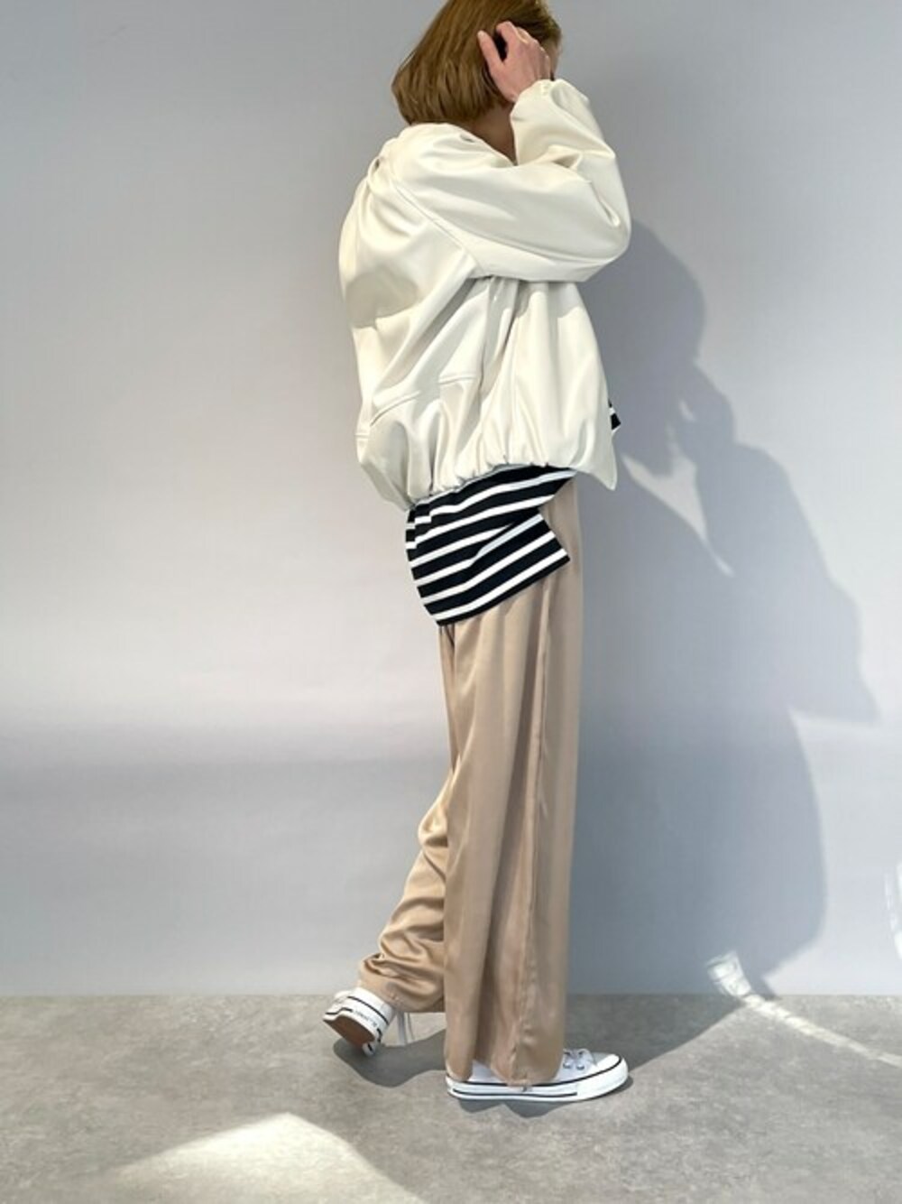 ホワイト系のブルゾン、ブラック系のTシャツ/カットソー、ベージュ系のその他パンツを着用したレディースの冬コーディネートの1枚目の写真