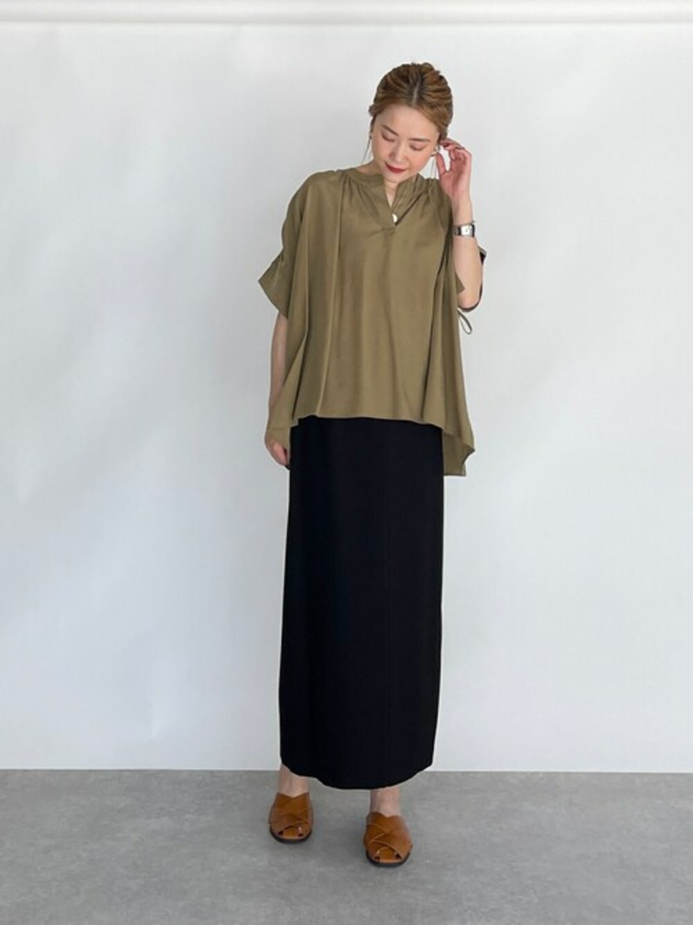 グリーン系のシャツ/ブラウス、ブラック系のスカートを着用したレディースの夏コーディネートの1枚目の写真