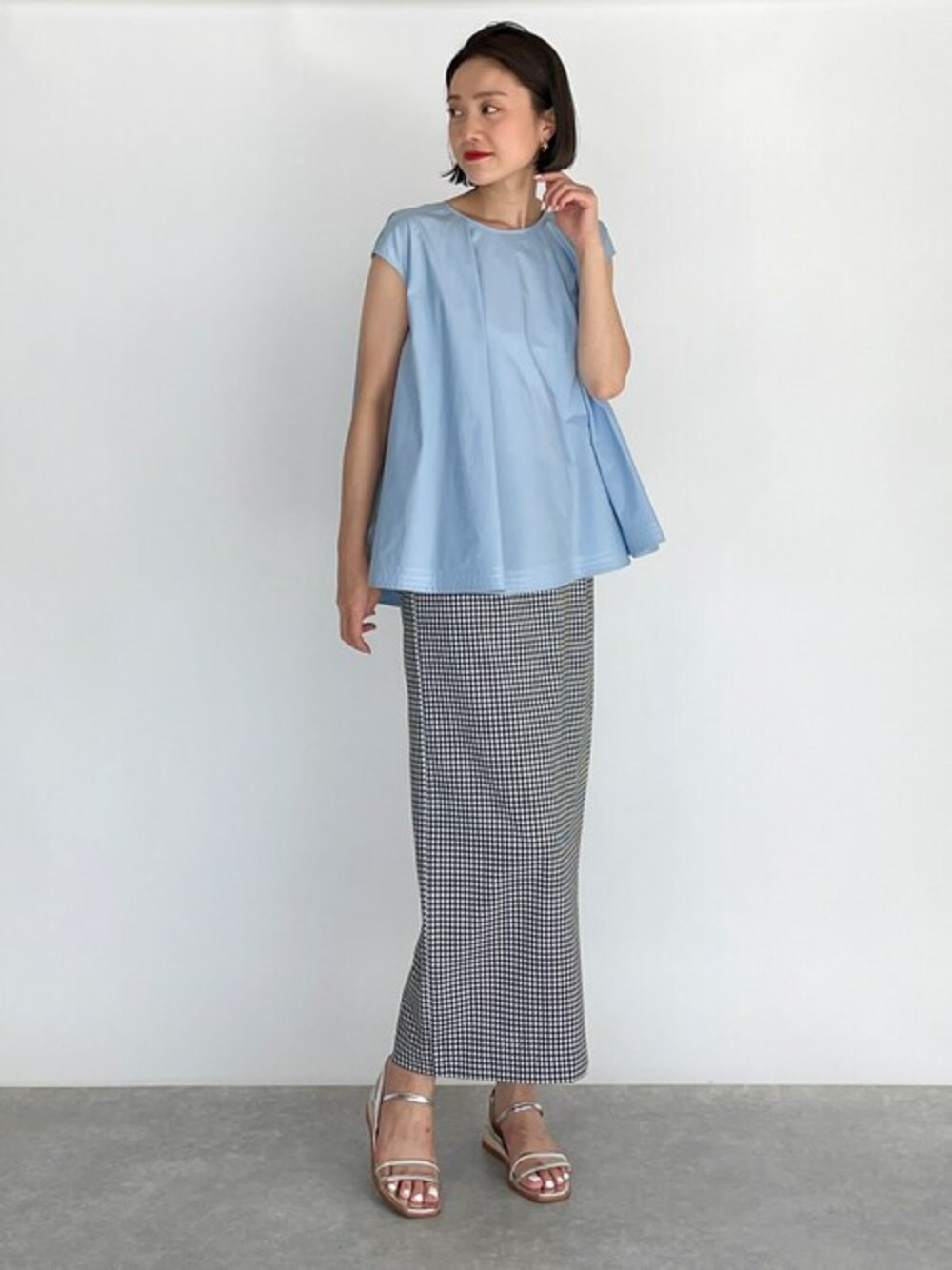 ブルー系のシャツ/ブラウス、ブラック系のジャンパースカート、シルバー系のサンダルを着用したレディースの夏コーディネートの1枚目の写真