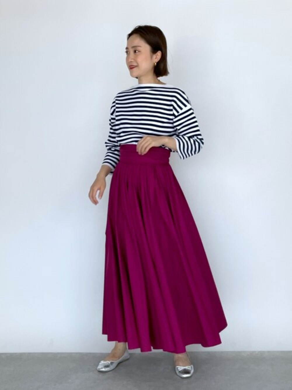 ブラック系のニット/セーター、パープル系のスカートを着用したレディースの夏コーディネートの1枚目の写真