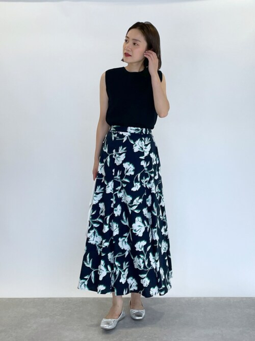 ブラック系のニット/セーター、ブラック系のスカートを着用したレディースの夏コーディネートの1枚目の写真