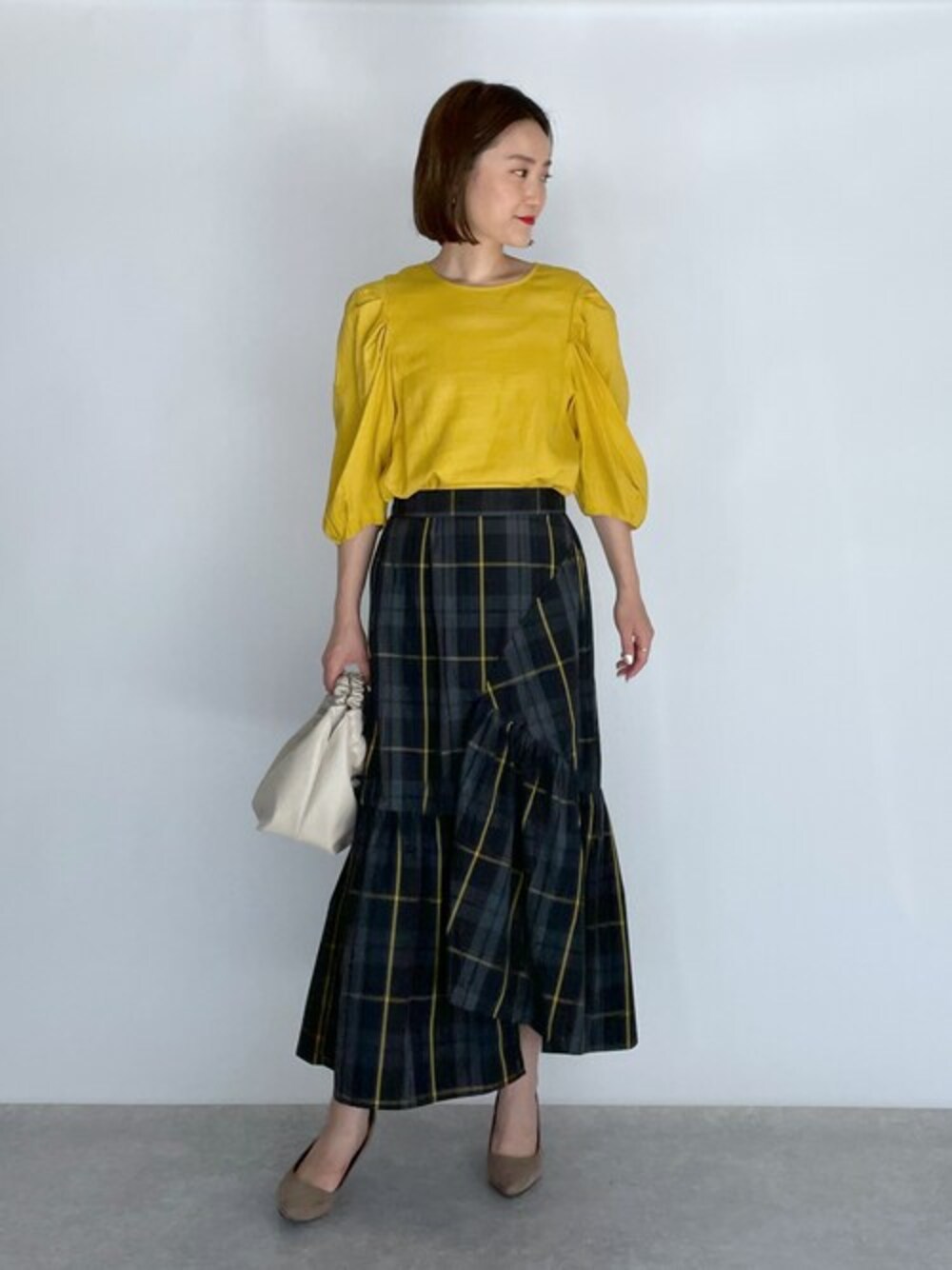 イエロー系のシャツ/ブラウス、ブラック系のスカートを着用したレディースの夏コーディネートの1枚目の写真