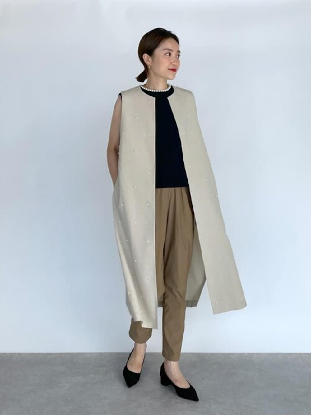 ベージュ系のベスト、ブラック系のニット/セーター、イエロー系のその他パンツを着用したレディースの秋コーディネートの1枚目の写真