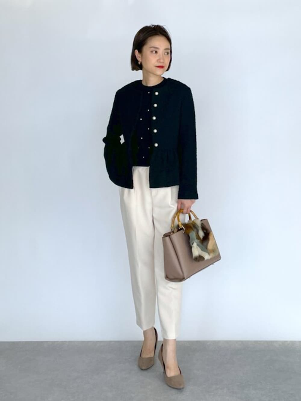 ブラック系のノーカラージャケット、ブラック系のニット/セーター、ホワイト系のその他パンツを着用したレディースの秋コーディネートの1枚目の写真