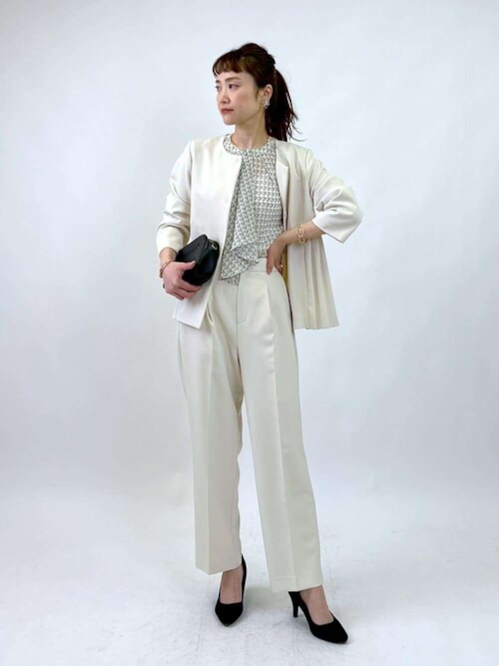 ベージュ系のスーツジャケット、ベージュ系のスーツパンツ、ホワイト系のシャツ/ブラウスを着用したレディースの冬コーディネートの1枚目の写真