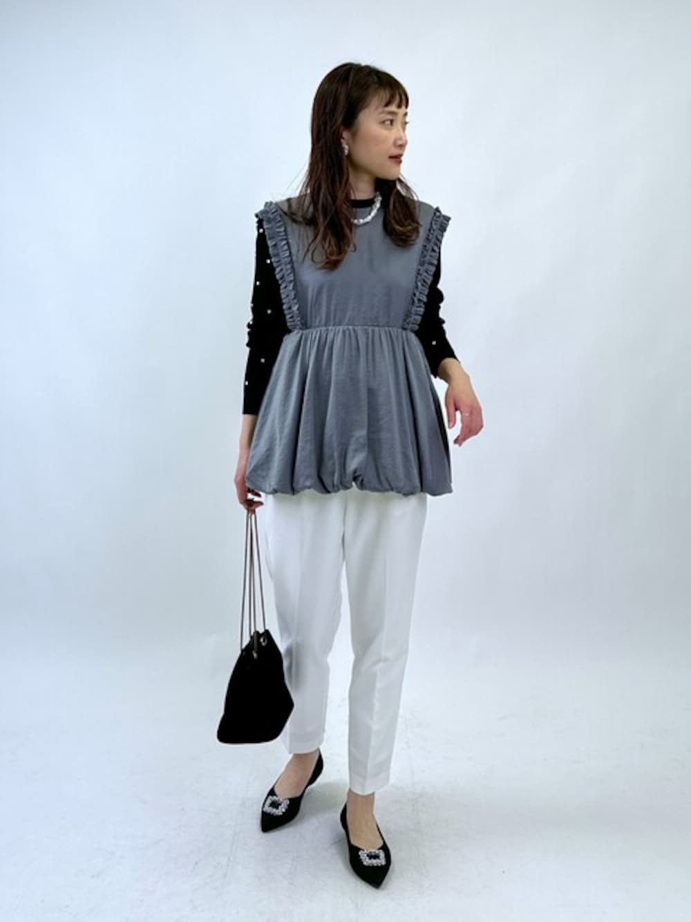 グレー系のシャツ/ブラウス、ブラック系のニット/セーター、ホワイト系のその他パンツを着用したレディースの冬コーディネートの1枚目の写真