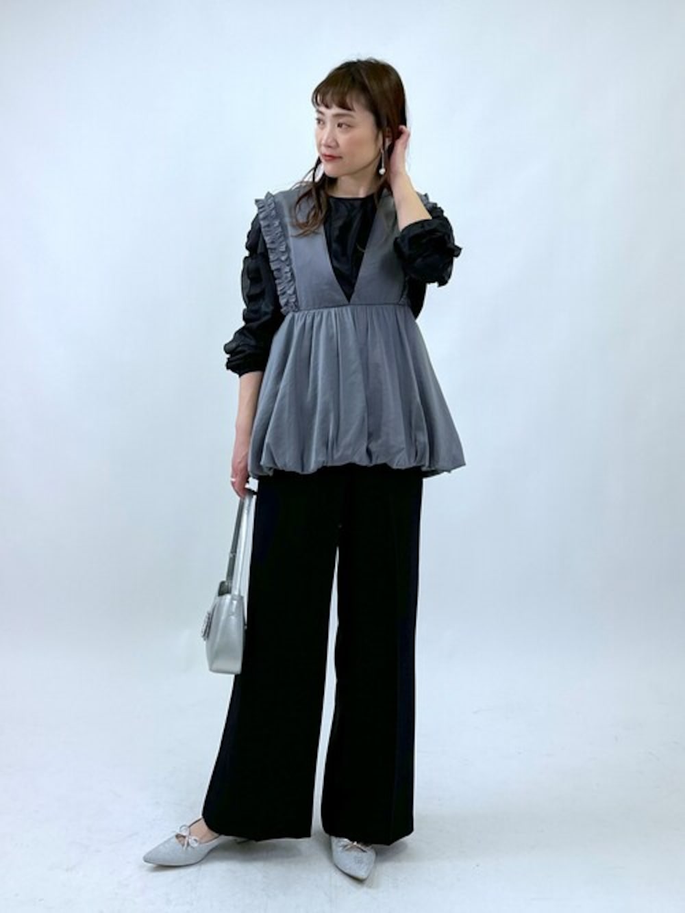 ブラック系のシャツ/ブラウス、グレー系のシャツ/ブラウス、ブラック系のスラックスを着用したレディースの春コーディネートの1枚目の写真