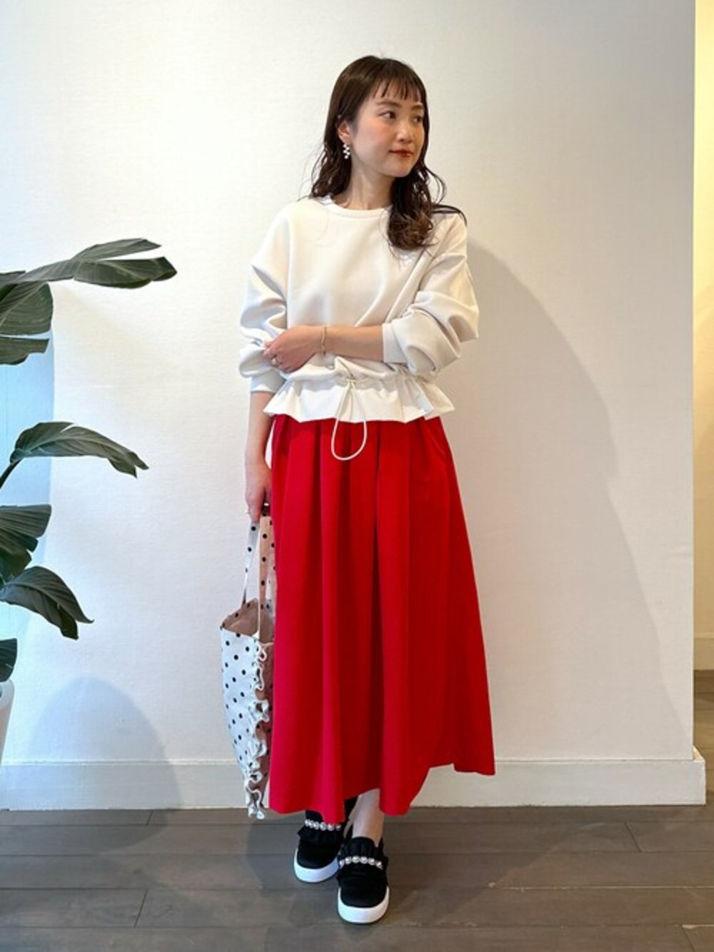 ホワイト系のTシャツ/カットソー、レッド系のスカート、ベージュ系のトートバッグを着用したレディースの春コーディネートの1枚目の写真