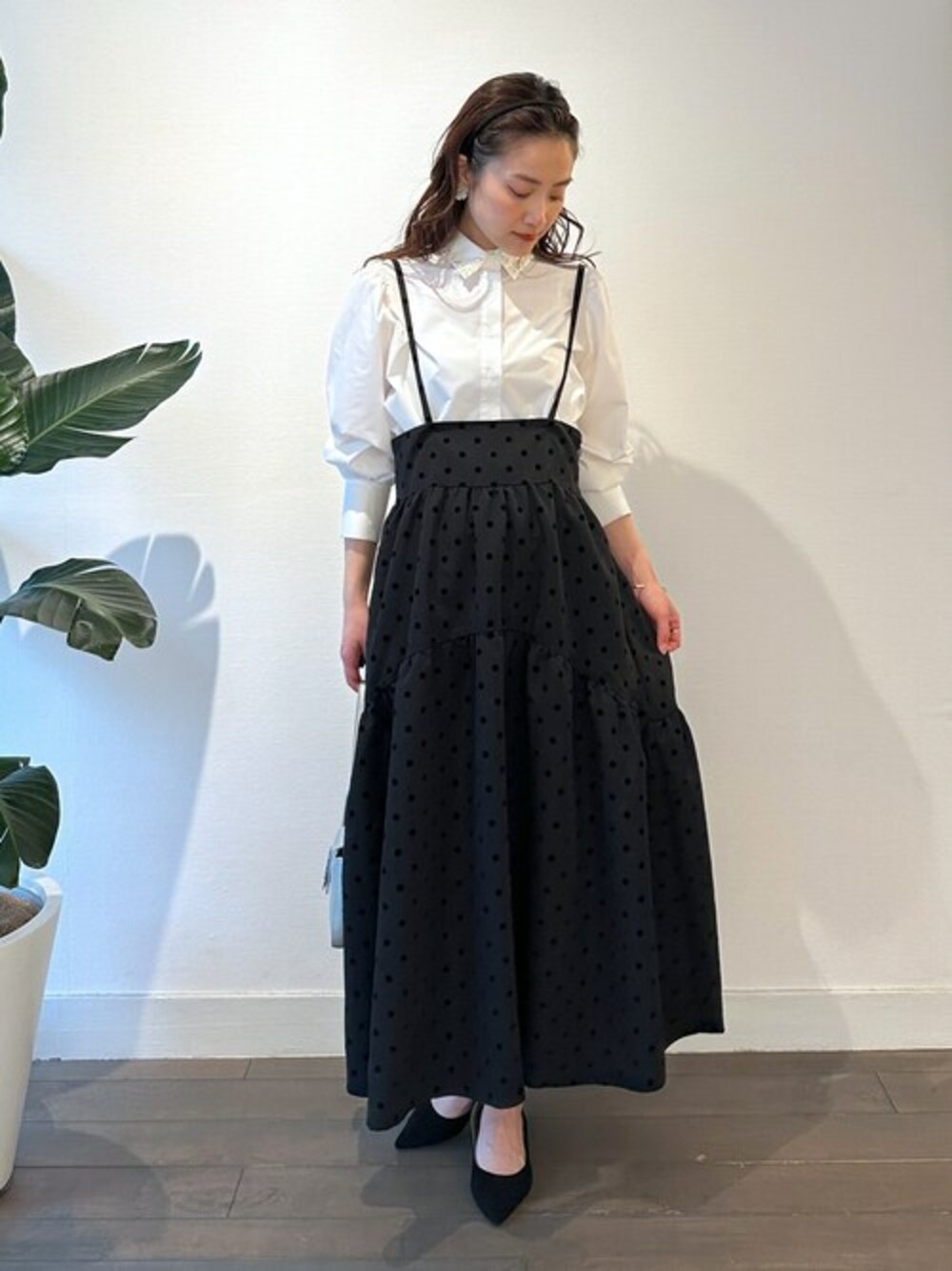 ホワイト系のシャツ/ブラウス、ブラック系のスカートを着用したレディースの春コーディネートの1枚目の写真