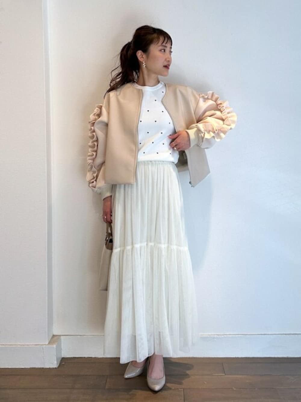 ホワイト系のブルゾン、ホワイト系のニット/セーター、ホワイト系のスカートを着用したレディースの春コーディネートの1枚目の写真