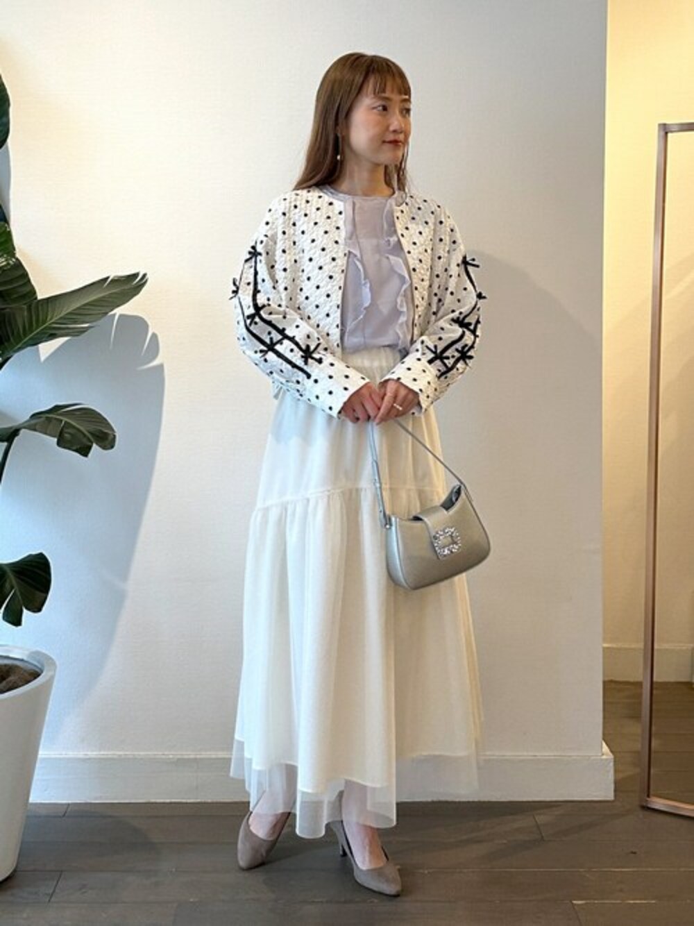 ホワイト系のノーカラージャケット、パープル系のシャツ/ブラウス、ホワイト系のスカートを着用したレディースの春コーディネートの1枚目の写真