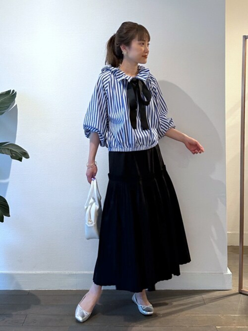 ブルー系のシャツ/ブラウス、ブラック系のスカートを着用したレディースの春コーディネートの1枚目の写真