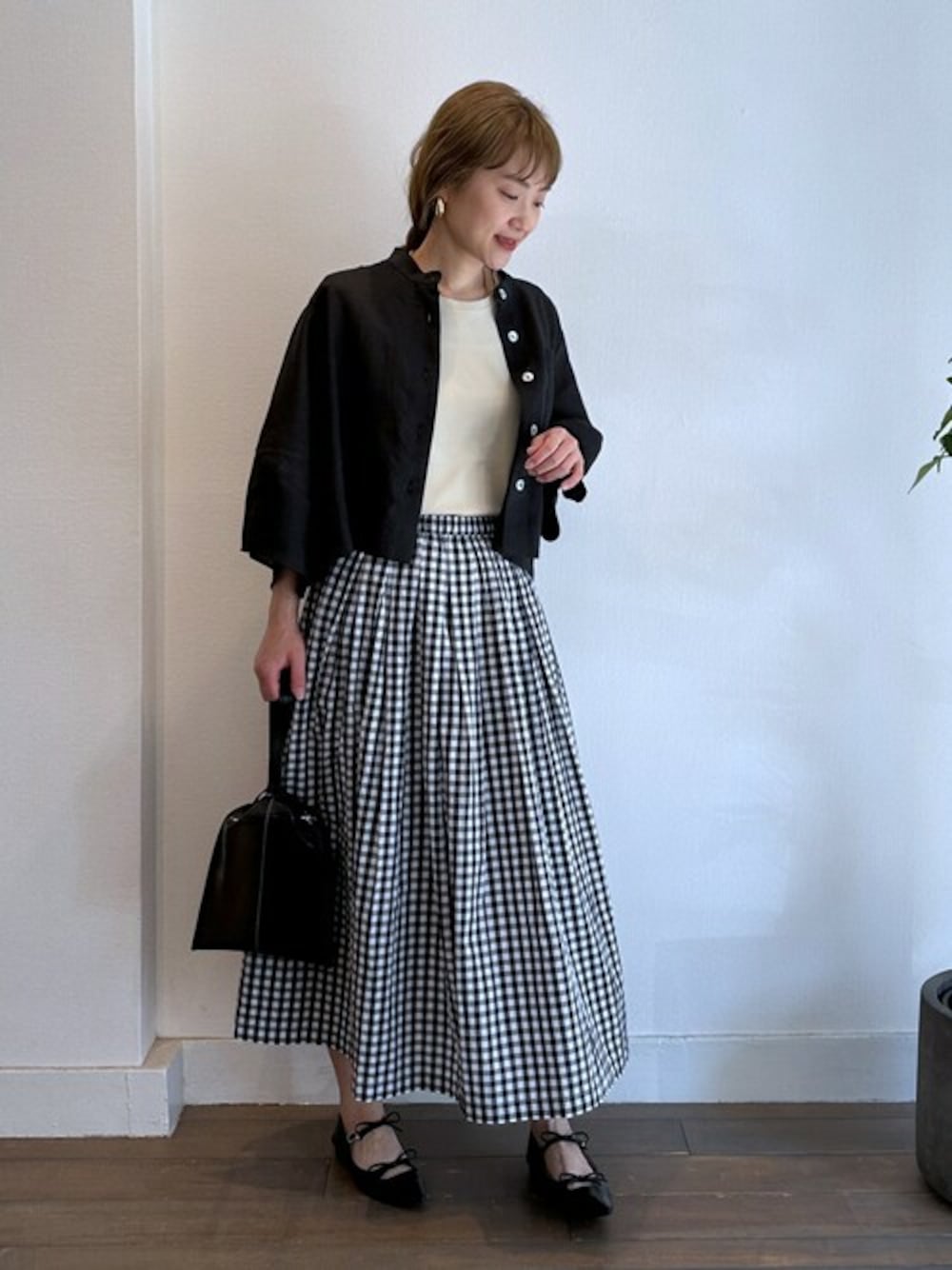 ブラック系のブルゾン、ホワイト系のTシャツ/カットソー、ブラック系のスカートを着用したレディースの夏コーディネートの1枚目の写真