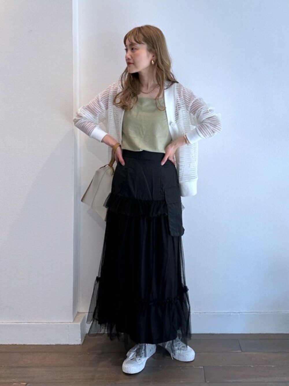ブラック系のカーディガン/ボレロ、グリーン系のタンクトップ、ブラック系のスカートを着用したレディースの夏コーディネートの1枚目の写真
