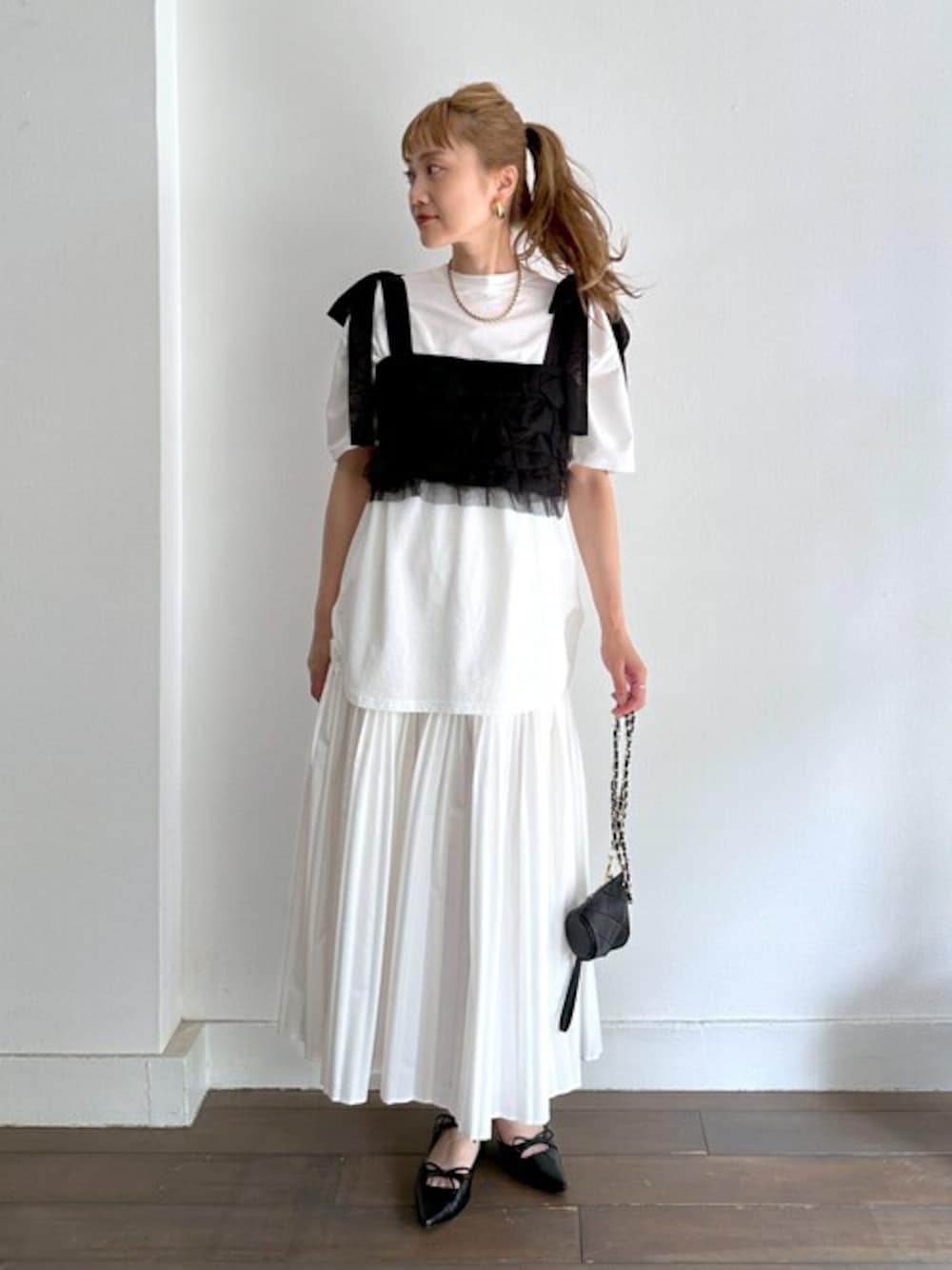 ブラック系のキャミソール、ホワイト系のTシャツ/カットソー、ホワイト系のスカートを着用したレディースの夏コーディネートの1枚目の写真