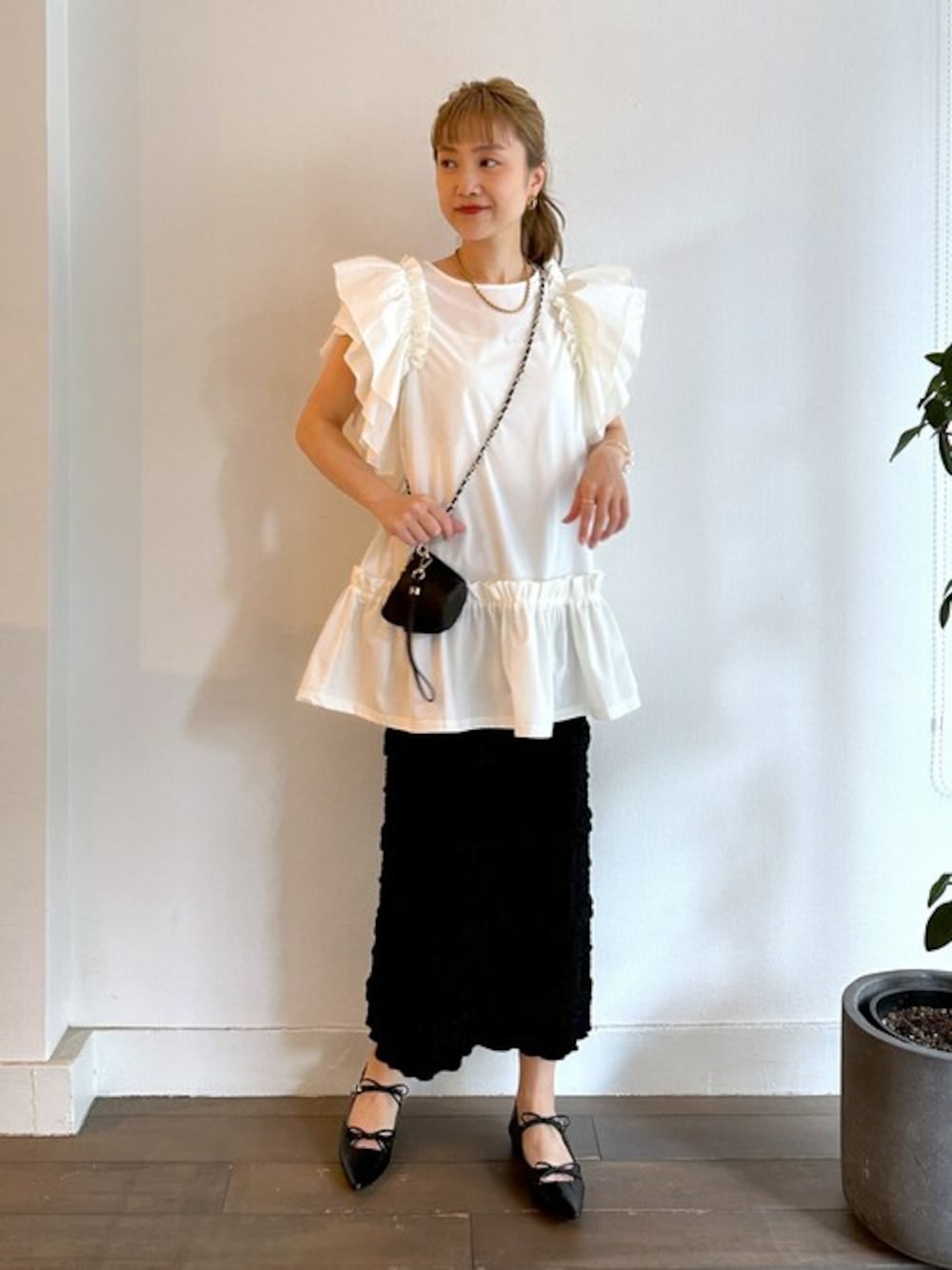 ホワイト系のTシャツ/カットソー、ブラック系のスカート、ブラック系のパンプスを着用したレディースの夏コーディネートの1枚目の写真