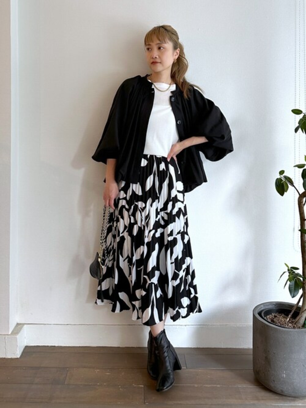 ブラック系のその他アウター、ホワイト系のTシャツ/カットソー、ブラック系のスカートを着用したレディースの秋コーディネートの1枚目の写真