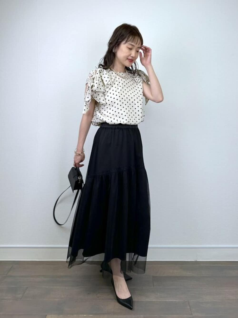 ホワイト系のシャツ/ブラウス、ブラック系のスカート、ゴールド系のネックレスを着用したレディースの夏コーディネートの1枚目の写真