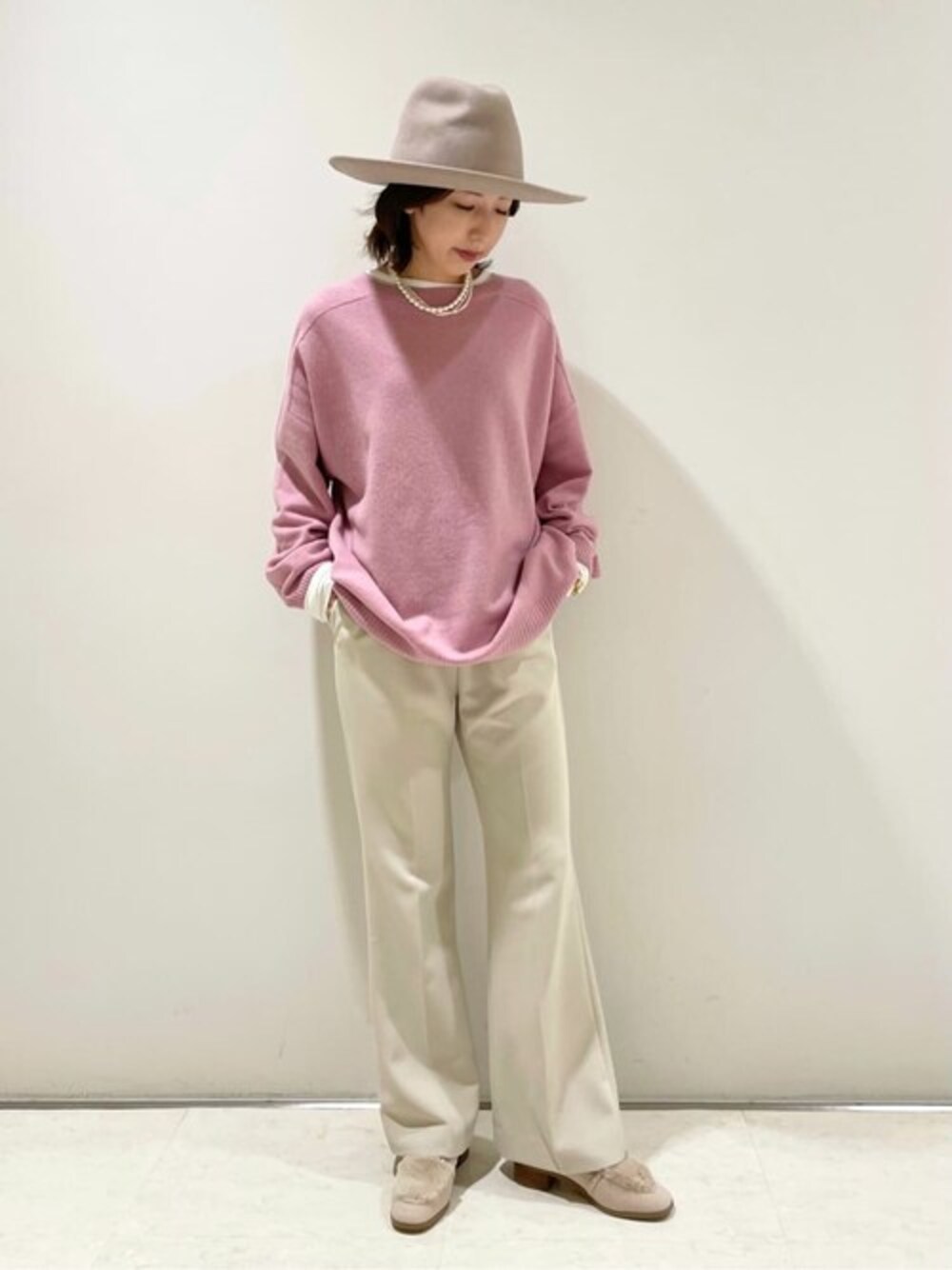 ホワイト系のパンプスを着用したレディースの秋コーディネートの1枚目の写真