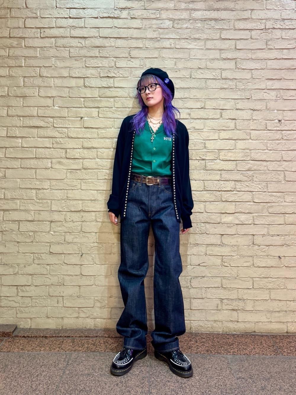 ブルー系のデニムパンツ、ブラック系のニット/セーター、グリーン系のシャツ/ブラウスを着用したレディースの春コーディネートの1枚目の写真