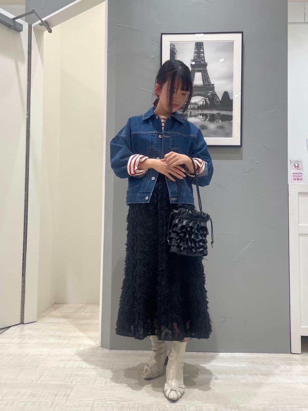 ブラック系のショルダーバッグ、ブルー系のデニムジャケット、ブラック系のスカートを着用したレディースの冬コーディネートの1枚目の写真