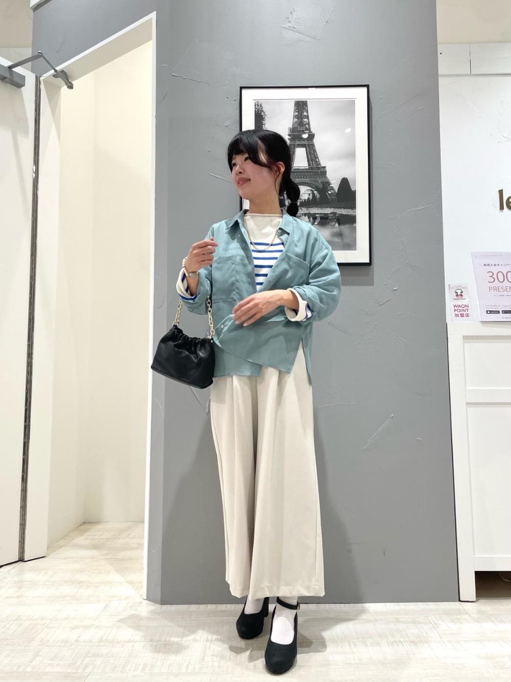 ブラック系のショルダーバッグ、ベージュ系のその他パンツ、ブルー系のシャツ/ブラウスを着用したレディースの春コーディネートの1枚目の写真