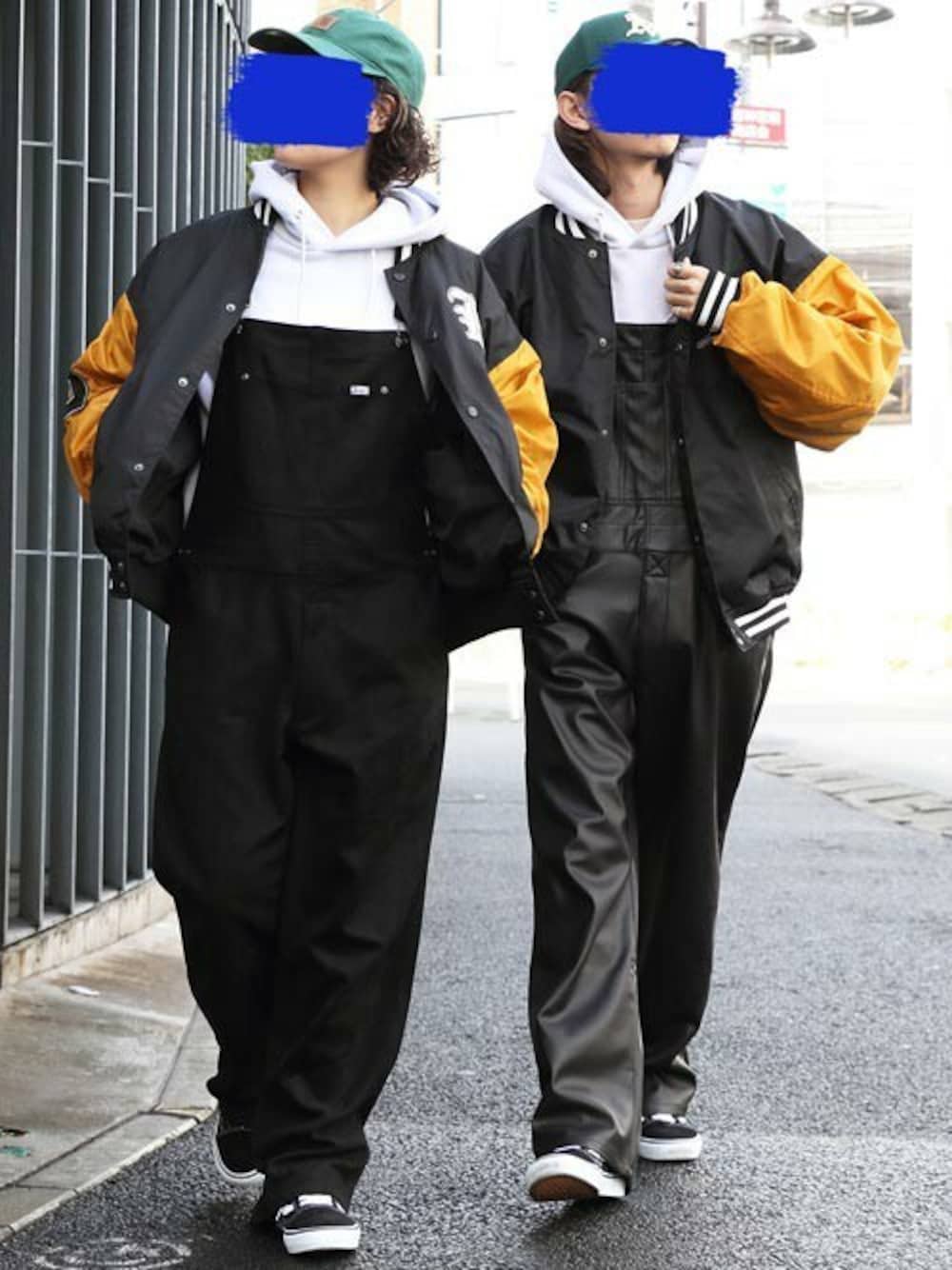 ブラック系のスタジャン、ホワイト系のパーカー、ブラック系のサロペット/オーバーオールを着用したメンズの春コーディネートの1枚目の写真