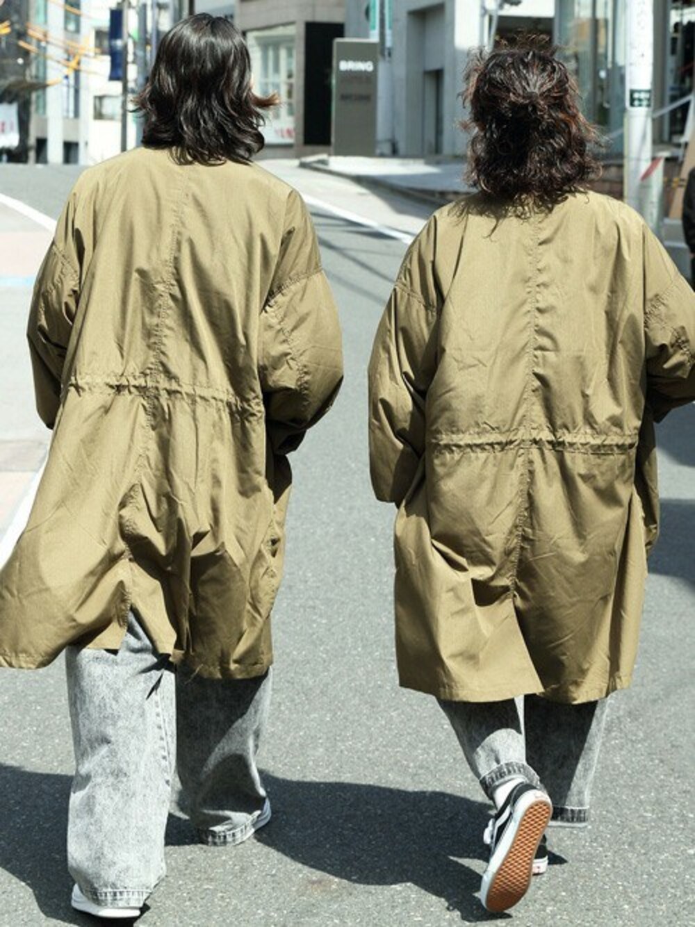グリーン系のモッズコート、ブラック系のTシャツ/カットソー、ブラック系のデニムパンツを着用したメンズの春コーディネートの1枚目の写真