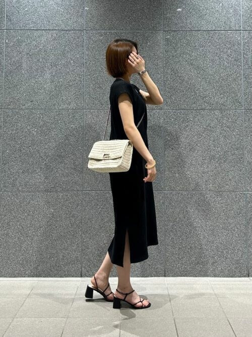 ブラック系のサンダル、ベージュ系のショルダーバッグを着用したレディースの夏コーディネートの1枚目の写真