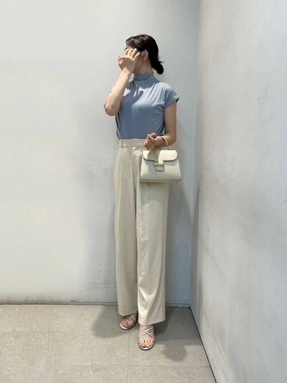 ベージュ系のハンドバッグを着用したレディースの夏コーディネートの1枚目の写真