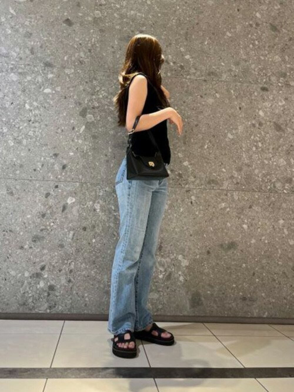 ブラック系のサンダル、ブラック系のショルダーバッグを着用したレディースの夏コーディネートの1枚目の写真