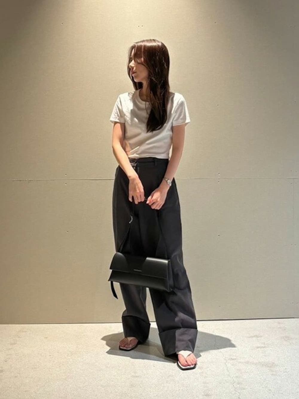 ブラック系のショルダーバッグ、ベージュ系のサンダルを着用したレディースの夏コーディネートの1枚目の写真