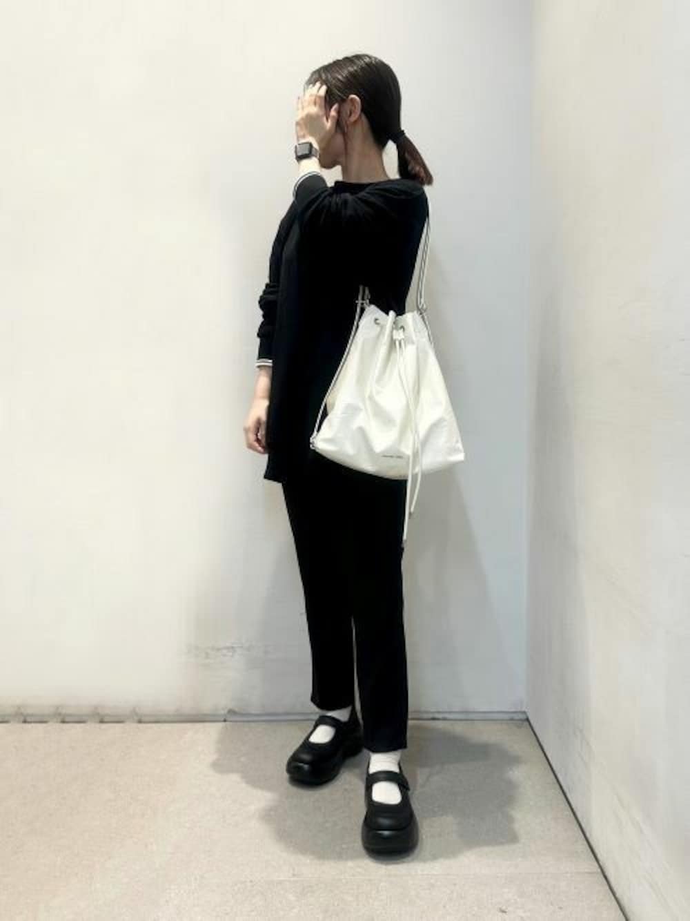 ベージュ系のショルダーバッグ、ブラック系のスニーカーを着用したレディースの夏コーディネートの1枚目の写真