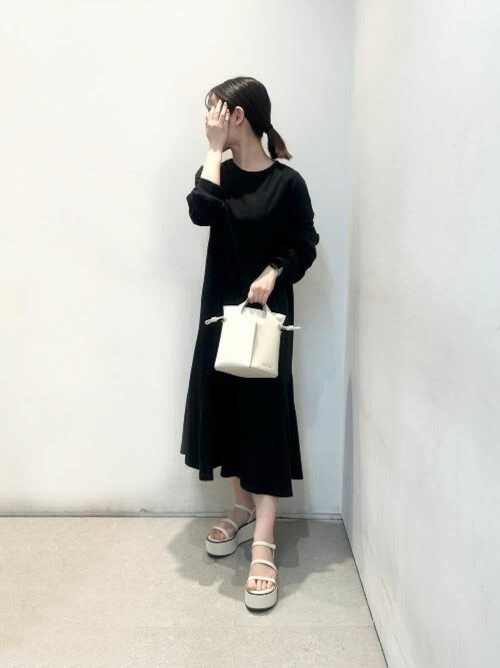 ベージュ系のショルダーバッグ、ホワイト系のサンダルを着用したレディースの夏コーディネートの1枚目の写真