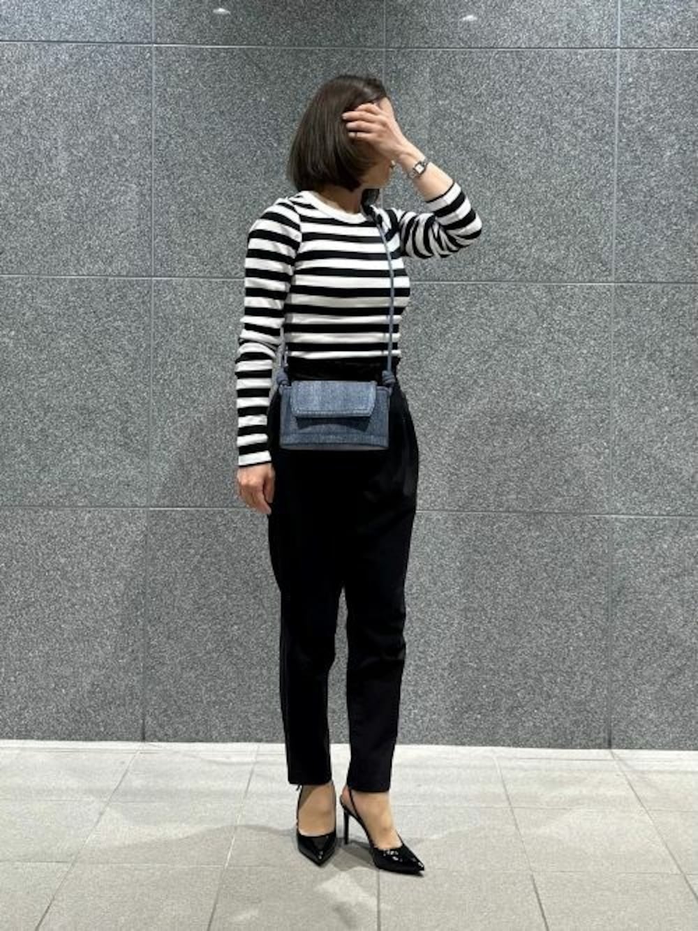 ブルー系のショルダーバッグ、ブラック系のパンプスを着用したレディースの夏コーディネートの1枚目の写真