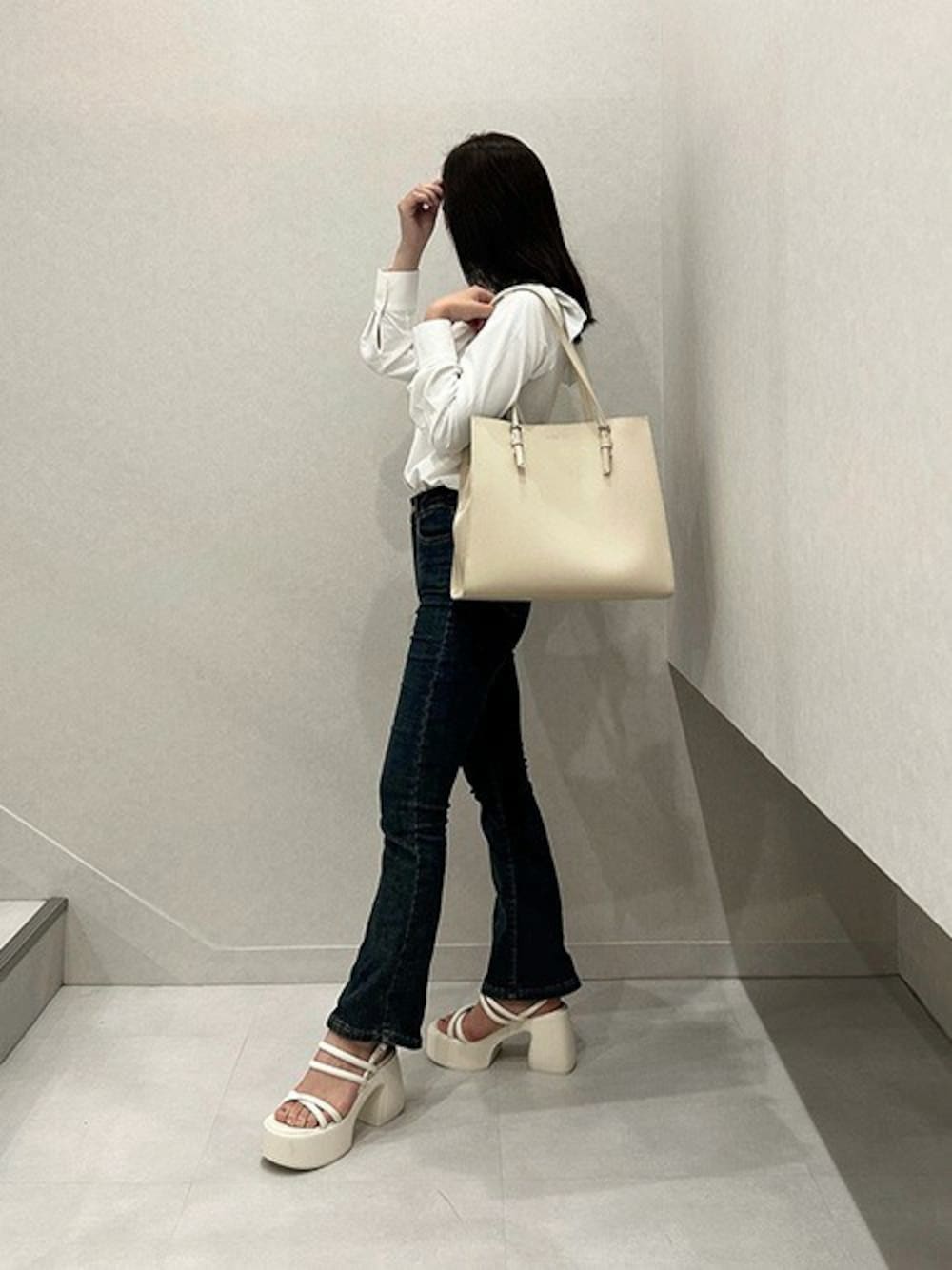 ベージュ系のトートバッグ、ホワイト系のサンダルを着用したレディースの夏コーディネートの1枚目の写真