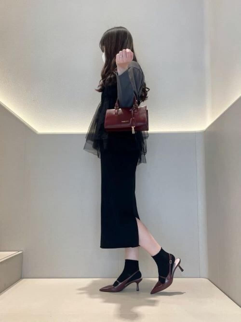 パープル系のトートバッグ、レッド系のパンプスを着用したレディースの冬コーディネートの1枚目の写真