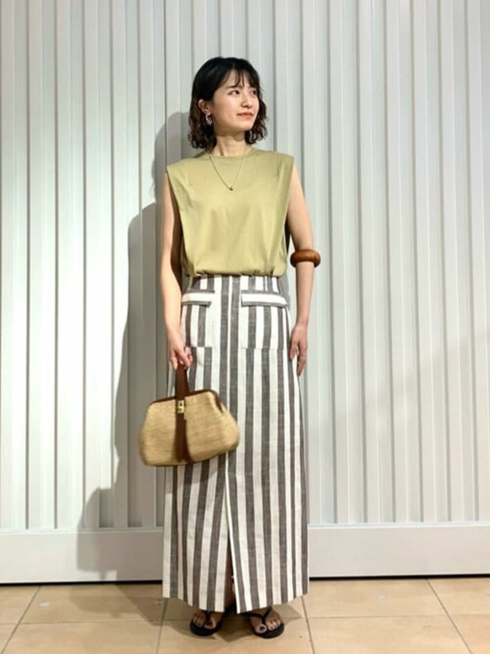 ブラウン系のスカート、ベージュ系のTシャツ/カットソーを着用したレディースの夏コーディネートの1枚目の写真