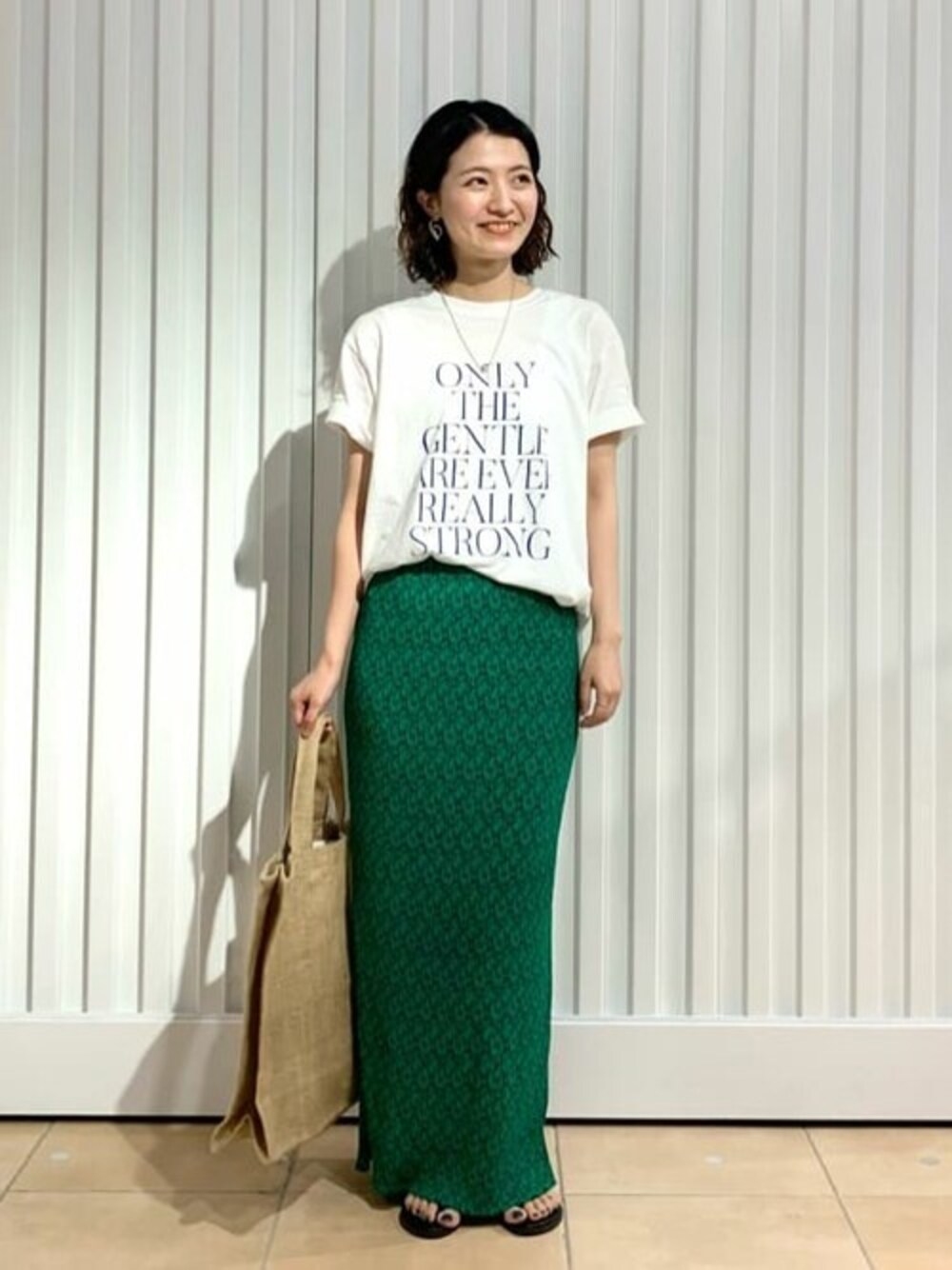 ホワイト系のTシャツ/カットソー、グリーン系のスカートを着用したレディースの夏コーディネートの1枚目の写真