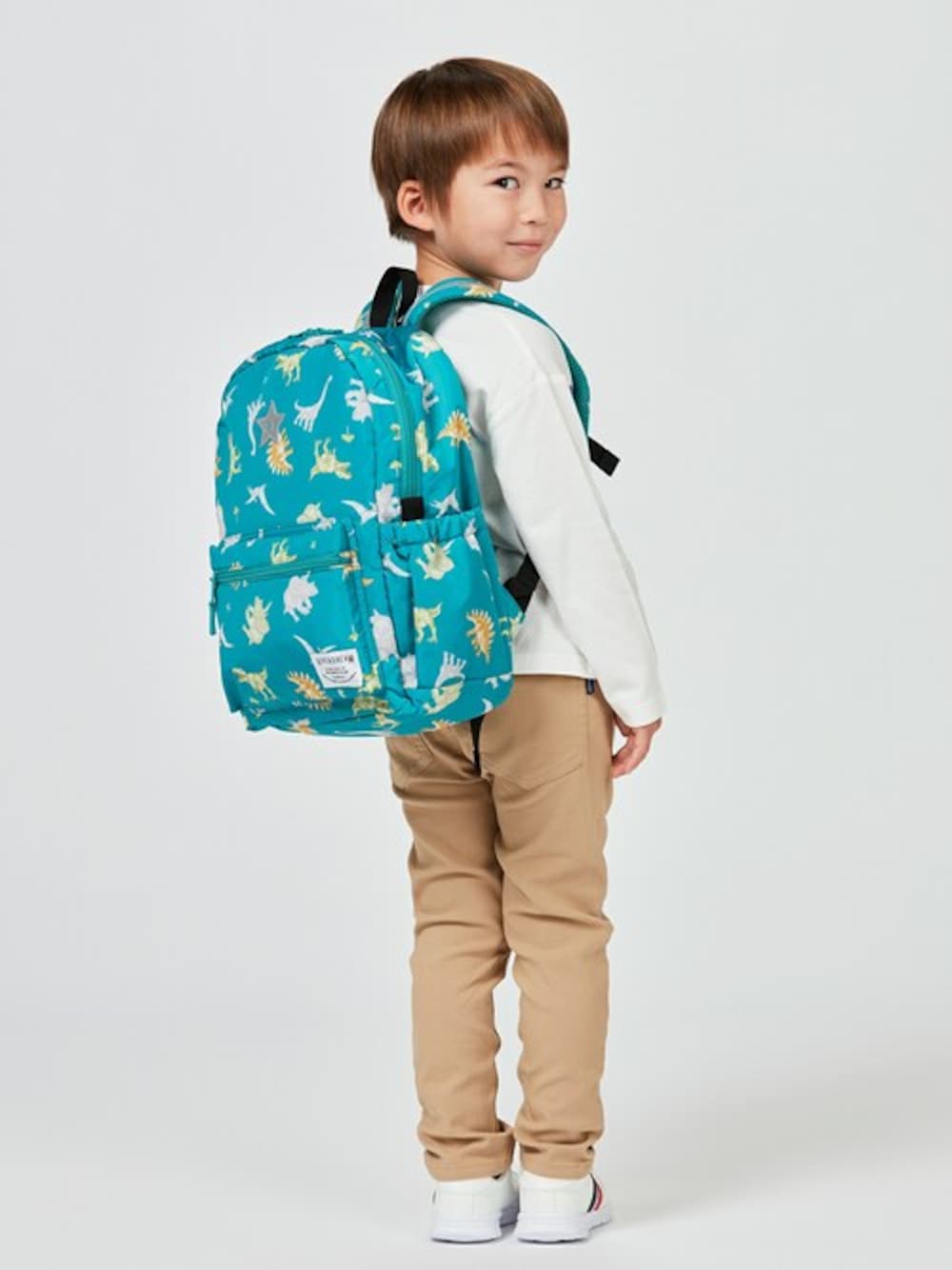 「リュック、リュックサック、バッグ、子供服、キッズコーデ、恐竜、カバン、恐竜柄、リュックスタイル、リュック・バッグ」｜「Kids Foretの花・うさぎ・恐竜・働く車総柄リュック（バックパック/リュック、グリーン系）」を使った、こどもの森e-shopさん（キッズ・110cm）の春コーディネートの1枚目の写真