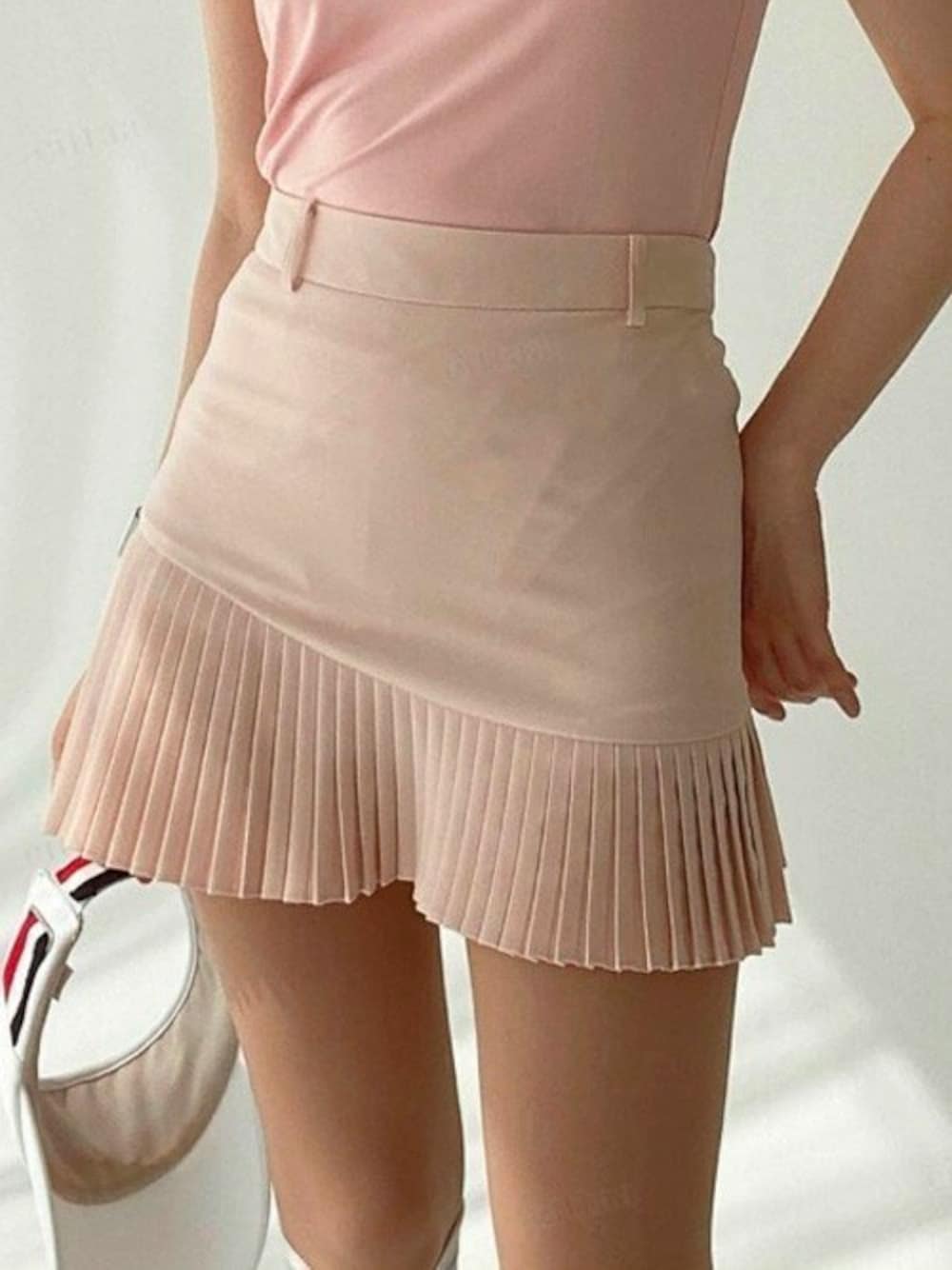 ピンク系のスカートを着用したレディースの秋コーディネートの1枚目の写真