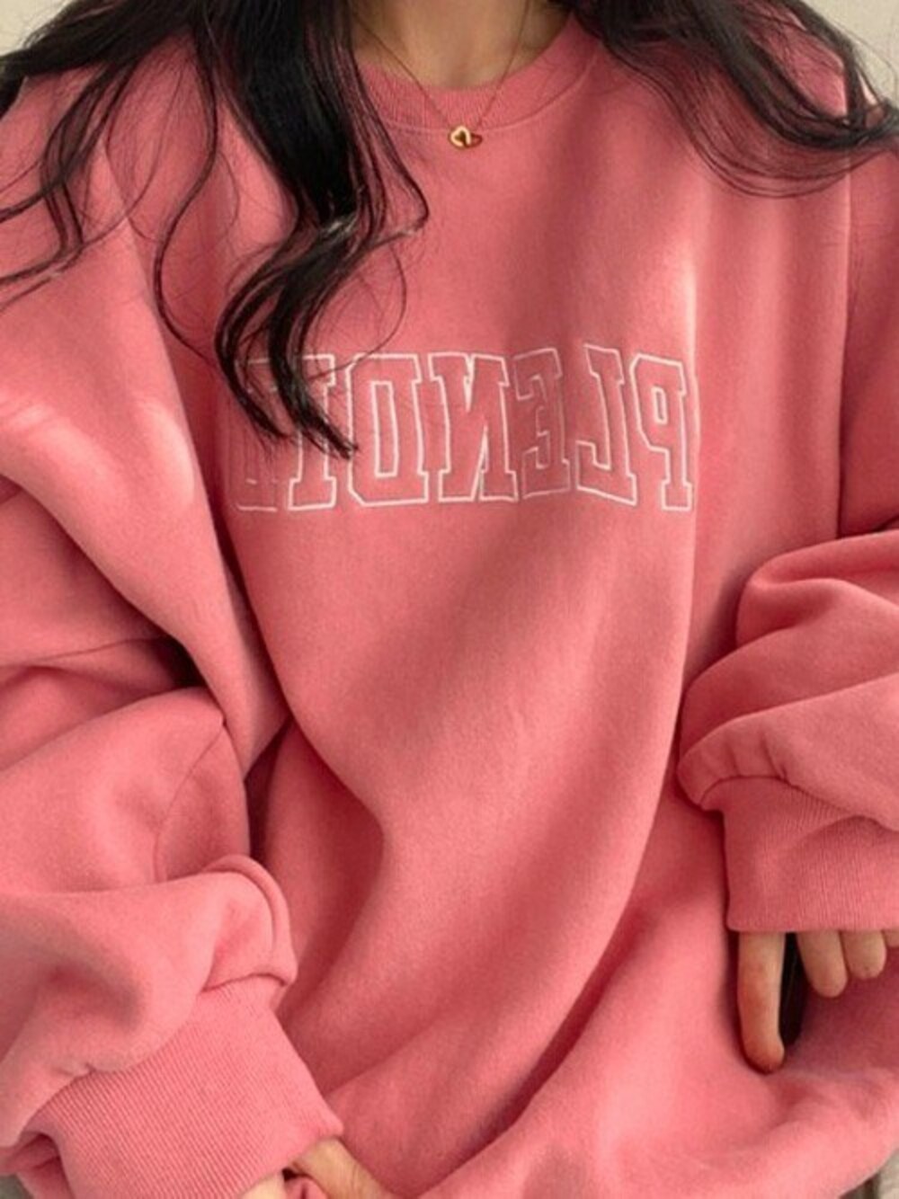 ピンク系のスウェットを着用したレディースの冬コーディネートの1枚目の写真